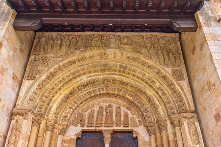 Intricate carvings and biblical scenes adorn the romanesque archivolt above the wooden door of San Esteban Church in Yesa, Navarre, Spainの写真素材