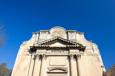 Weathered facade of the Church of St. Julian with columns and sundial, located in Arles, Franceの写真素材