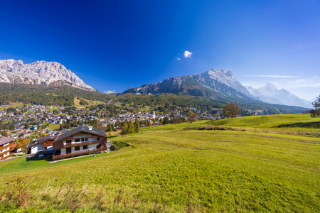 Scenic view of Sappada, a charming village nestled in the Italian Alps, surrounded by green meadows and majestic peaksの写真素材