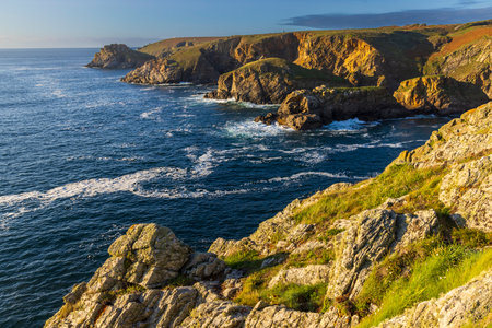 Pointe de Kastell Koz in Cleden Cap Sizun, Brittany, is illuminated by the setting sun, creating a...
