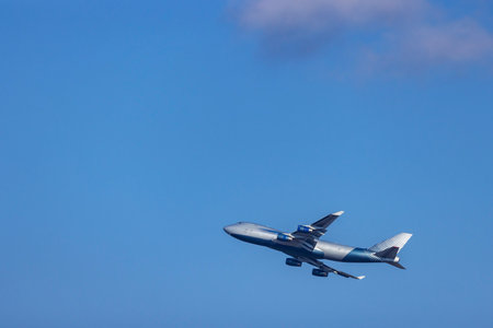 Jumbo jet aircraft gaining altitude in the clear blue sky over North Holland, Netherlands, near Schiphol Airportの写真素材