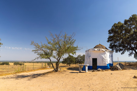 Small rural chapel standing near a dirt road in the dry fields of Montemor o Novo, Evora district, Alentejo region, Portugal, on a sunny summer dayの写真素材