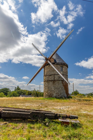Old windmill of La Roche in La Possonniere, France, standing in a field under a cloudy skyの写真素材