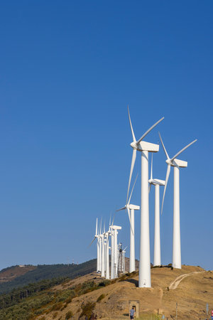 Wind turbines are producing renewable energy on a hill, symbolizing sustainable development and...