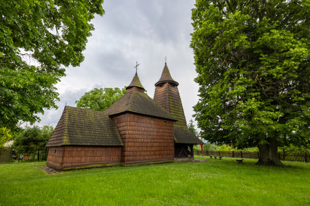 Traditional wooden church standing on green grass in Trocany, Slovakia, a testament to historical architectureの写真素材