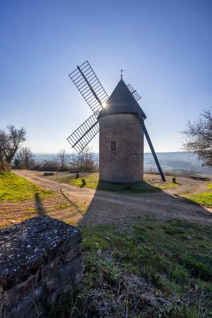 Traditional windmill standing on a hill in Santenay, Bourgogne Franche Comte, France, during a sunny...