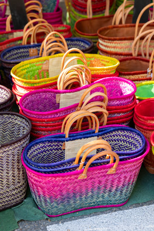 Colorful handmade baskets with leather handles are for sale at a local market in Nyons, Franceの写真素材