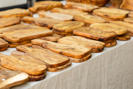 Olive wood cutting boards for sale at a market in Nyons, France, showcasing craftsmanship and natural beautyの写真素材