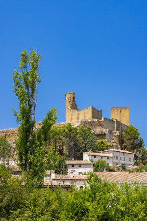 Medieval castle ruins standing tall above the town of Uncastillo in the Cinco Villas region of Aragon, Spain, under a clear blue skyの写真素材