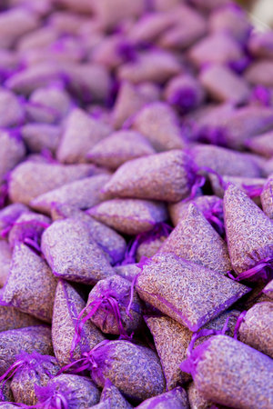 Close up of numerous lavender sachets, tied with purple ribbons, creating a vibrant display in a traditional French market in Nyons, Dromeの写真素材