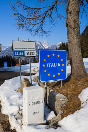 Road signs marking the border between Slovenia and Italy near Bovec during winterの写真素材