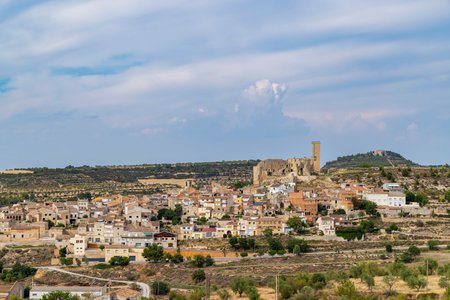 Panoramic view of the medieval castle dominating the village of Ciutadilla, in Catalonia, Spain, under a cloudy skyの写真素材