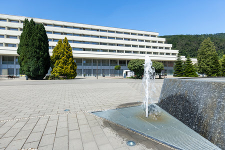Fountain splashing water in front of modern spa hotel in Trencianske Teplice, Slovakia, during sunny summer dayの写真素材