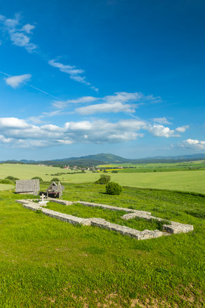 Ancient ruins of Great Moravian Basilica in Strba, Slovakia, surrounded by green fields and hillsの写真素材