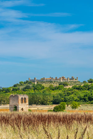 Ruins of an ancient building in the foreground with Monteriggioni in the background, in the heart of Tuscany, Italyの写真素材
