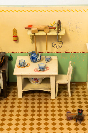Charming miniature kitchen setup showcasing vintage tableware, utensils, and furniture in a Czech home, evoking nostalgia and childhood memoriesの写真素材