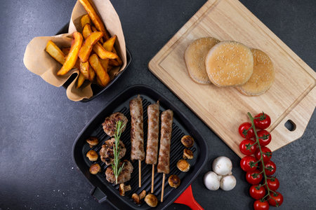 grilled meat and shasliks with mushrooms and tomatos served with french fries