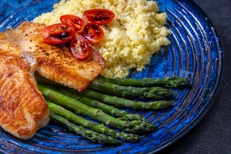 Green asparagus with fish fillet and couscousの写真素材