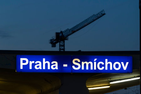 Praha Smichov train station sign illuminating with a construction crane in a dark skyの写真素材