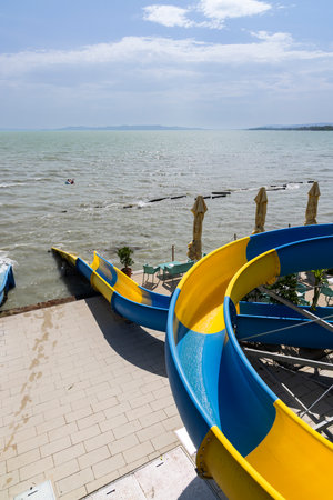Water slides providing summer fun plunging directly into the calm waters of lake Balatonの写真素材