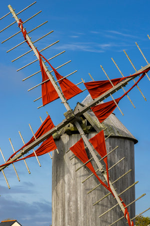 Traditional windmill blades with red sails standing against a blue sky in Cleden Cap Sizun, Brittanyの写真素材
