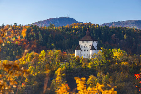 New Castle Banska Stiavnica standing on a hill surrounded by colorful autumn forestの写真素材