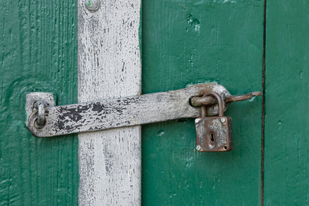 Weathered metal padlock and latch on an aged green door in Zellerndorf, Lower Austriaの写真素材