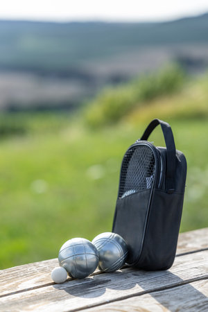 Petanque boules and cochonnet resting on a wood table, enjoying outdoor leisure activityの写真素材