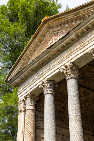 Ancient Roman style temple showing columns, pediment detail, and Latin inscriptionの写真素材