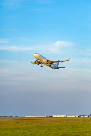 Commercial airplane departing for travel, flying into a clear sky over Hostivice, Czechiaの写真素材