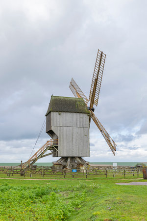 Historic post windmill standing in a green field under a cloudy sky in Valmyの写真素材