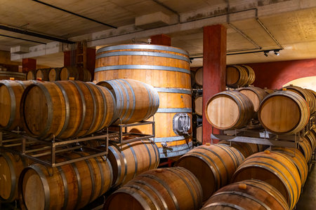 Wooden aging barrels and a large vat filling a traditional cellar in Finistere, Brittany, France