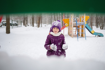 baby girl playing snowballs in winter Park. outdoor funの写真素材