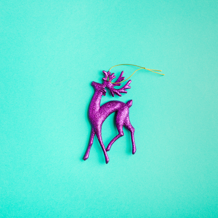 shiny purple deer on turquoise background.Christmas toy. minimalism.の写真素材