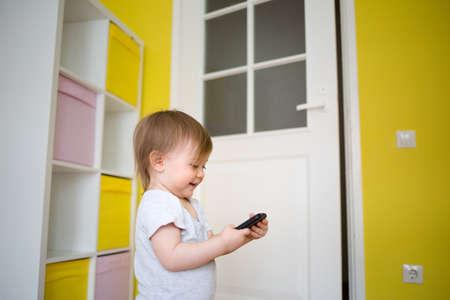 baby is talking on the phone with his grandmother. kid and mobile. childrens roomの写真素材