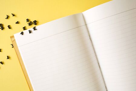Notepad notebook and 3d black letters on yellow background. concept back to school office supplies....