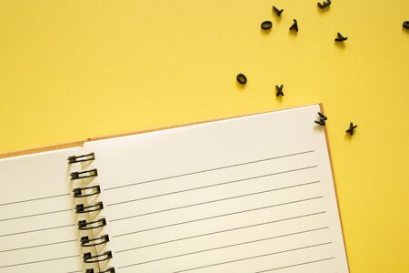 Notepad notebook and 3d black letters on yellow background. concept back to school office supplies. Teachers desk. Students book. running textの写真素材