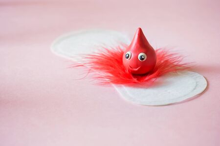 Menstrual daily sanitary pad with red feather drop of blood on pink background. Minimal concept care clean softの写真素材
