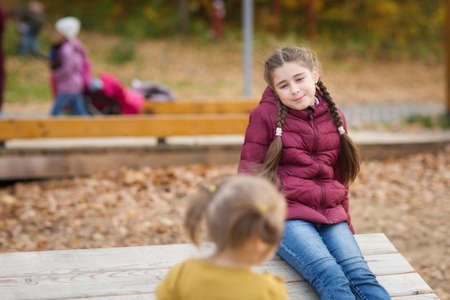 children walk in Park in autumn. season outdoors. natural emotions on girl's face.