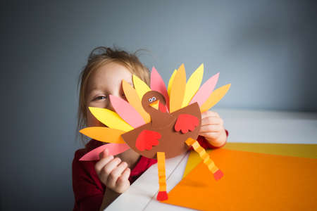 paper craft for kids. DIY Turkey made for thanksgiving day. create art for children. girl playing...