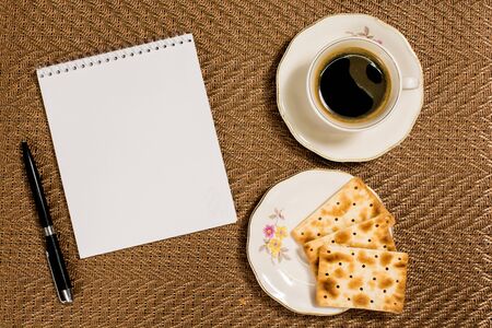 notepad with coffee, cookies on golden backgroundの写真素材