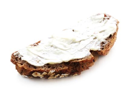 A Slice Of Buttered Whole Grain Bread Isolated On White