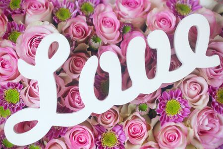 The Word "Love" in Wood On A Floral Backgroundの写真素材