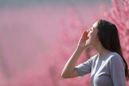 Profile of a happy woman shouting in a field in spring seasonの写真素材