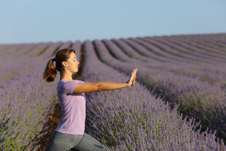Profile of a woman practicing tai chi exercises in lavender fieldの写真素材