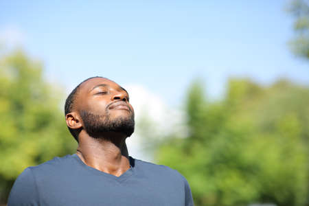 Man with black skin breathing fresh air in nature a sunny dayの写真素材
