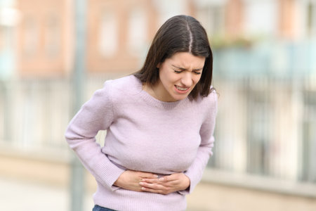 Teen suffering stomach ache in the streetの写真素材