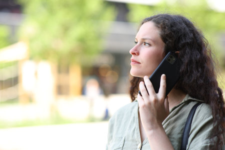 Woman talking on phone walking in the street
