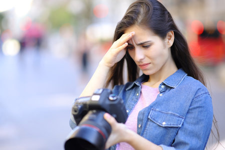 Worried photographer checking photoshoot results on camera in the street