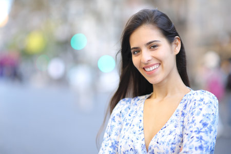 Happy woman posing looking at camera standing in the streetの写真素材